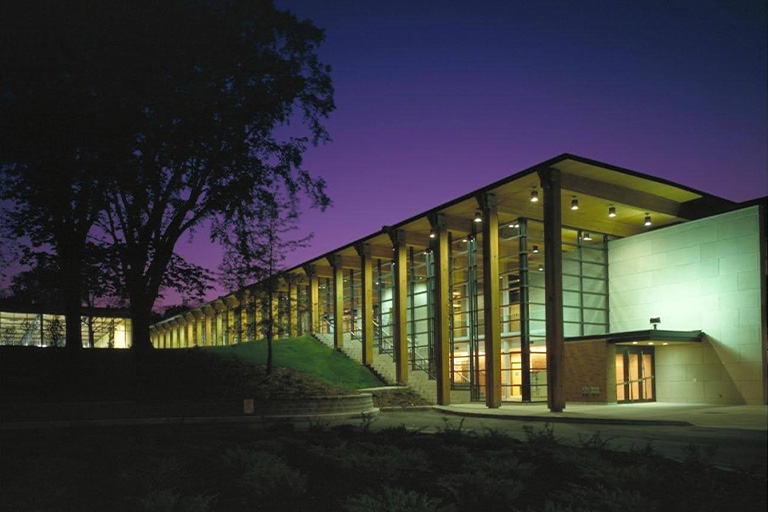 An exterior staircase next to a glass building in dusk light